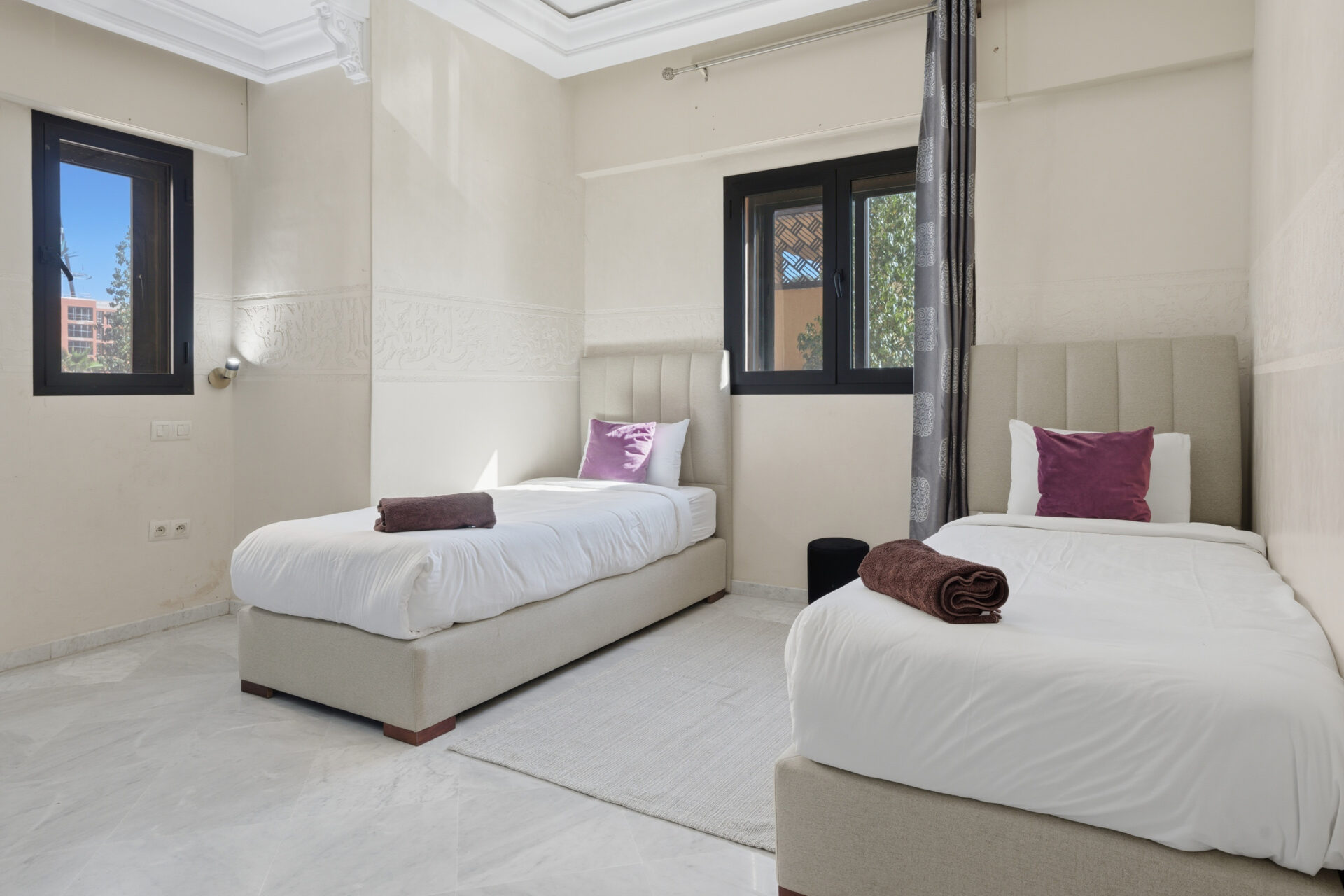 Conciergerie villa Marrakech : un jardinier taillant des buissons près d’une piscine étincelante – Your Host Marrakech