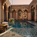 Villa marocaine avec piscine et patio, illustrant une conciergerie villa Marrakech au coucher du soleil