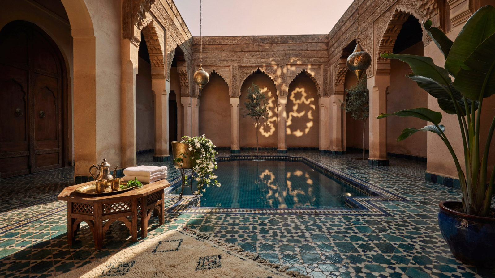 Villa marocaine avec piscine et patio, illustrant une conciergerie villa Marrakech au coucher du soleil