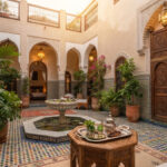 Marrakech concierge welcoming guests in a traditional riad courtyard