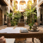 Marrakech riad concierge reviewing a budget sheet on a courtyard table